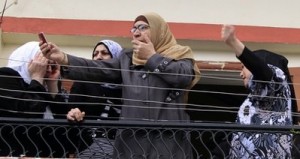 Residents  react as they take pictures of the hanging body of Egyptian Mohammed Msallem after he was stabbed to death in Ketermaya village in Mt Lebanon